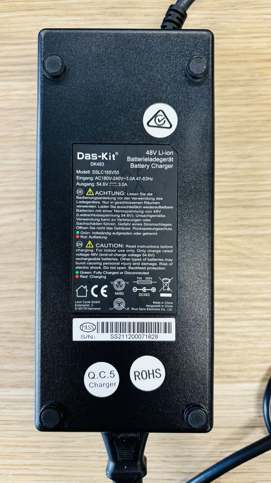 Close-up of Das-Kit charger for NCM Cru7s Step-Through Cruiser E-Bike by SalteBikes, designed for fast and efficient charging of the 48V battery.